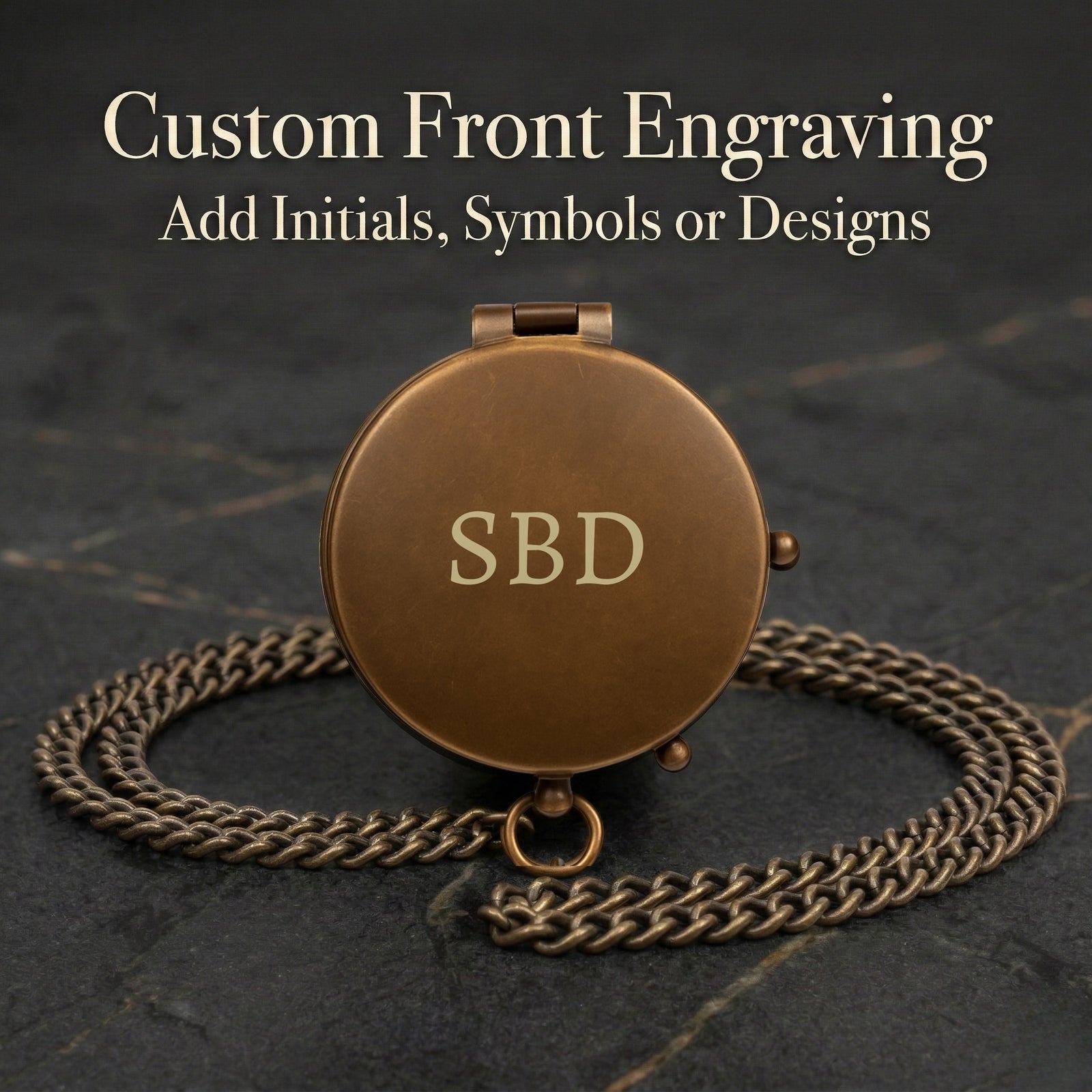 Bronze locket with 'SBD' engraving on a dark background