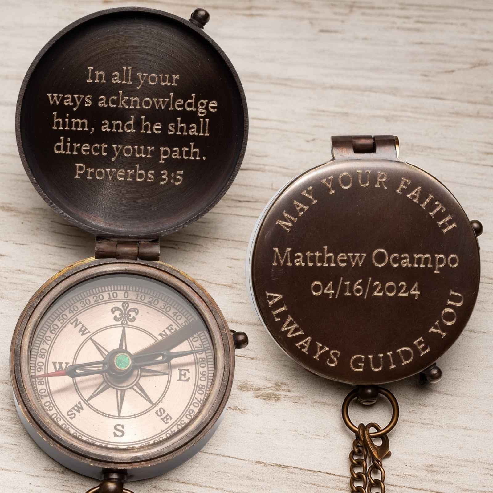 Decorative compass with engraved text on a wooden surface