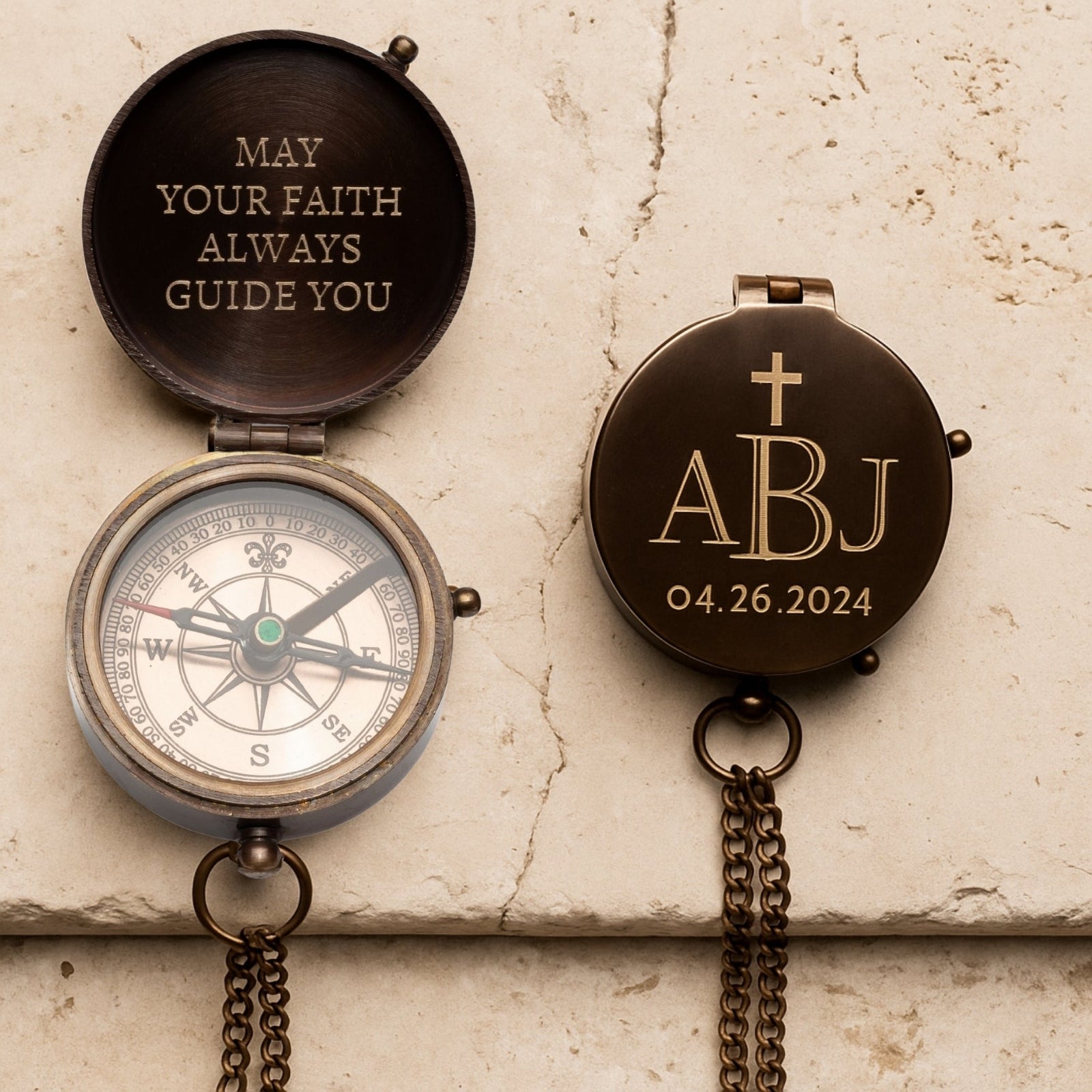 Decorative compass with engraved text and initials on a textured surface