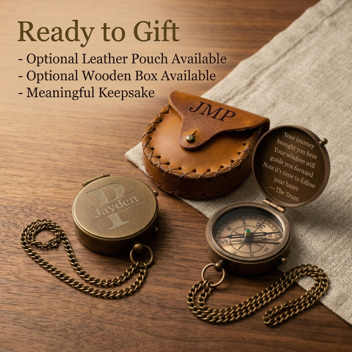 Two brass compasses with leather pouch and wooden box on a wooden surface