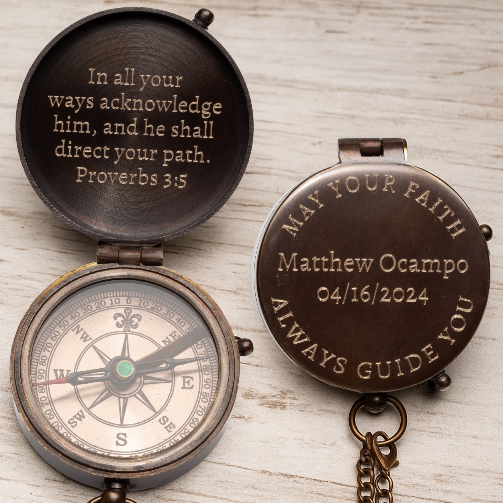 Decorative compass with engraved text on a wooden surface