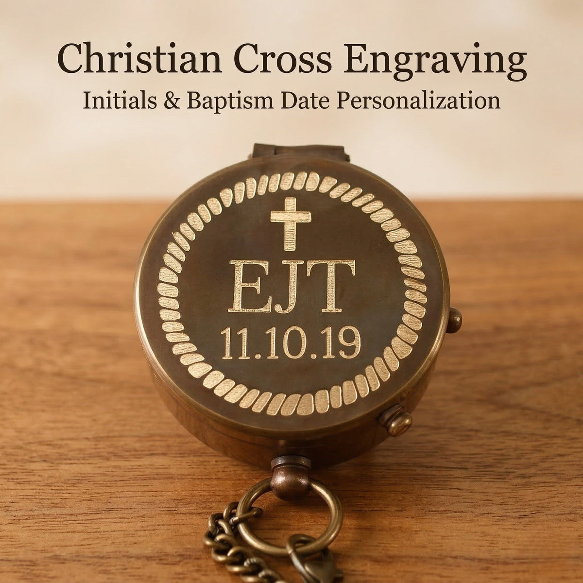 Personalized bronze compass with Christian cross engraving on a wooden surface