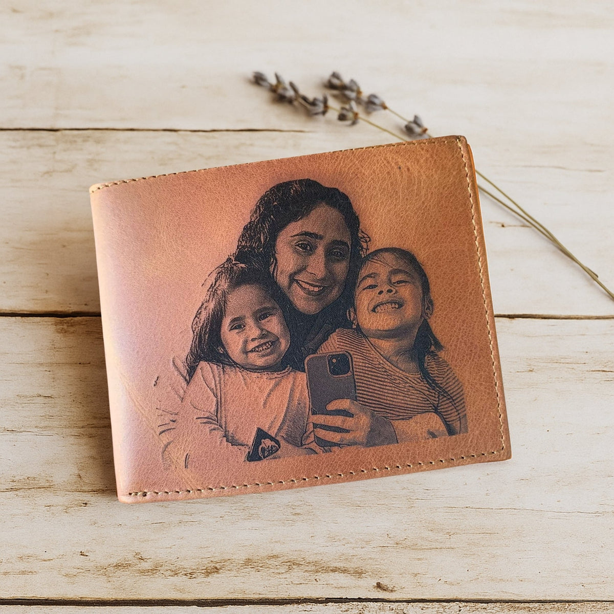 Brown leather wallet with a printed design of a woman and two children on a wooden surface.
