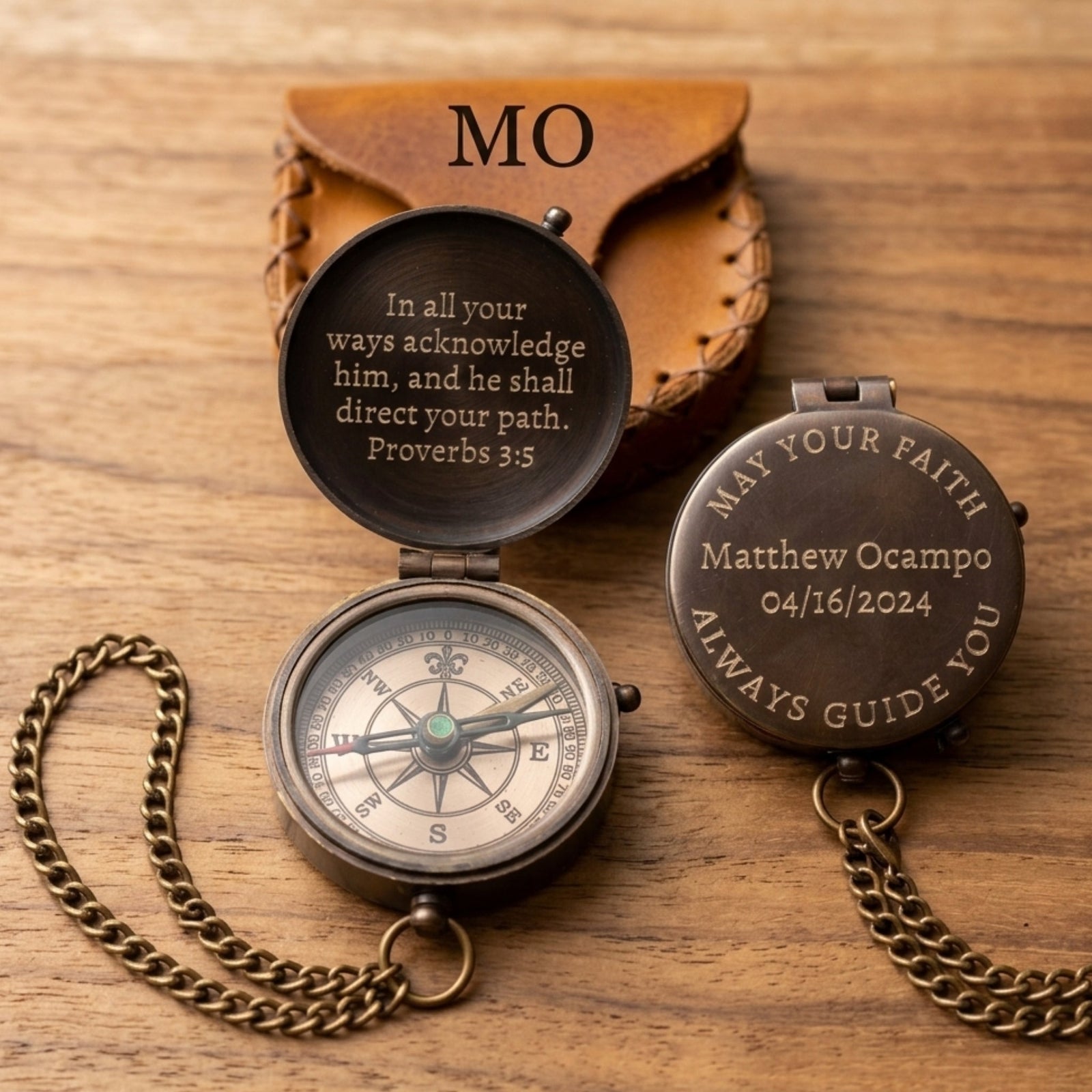 Personalized compass with engraved text on a wooden surface