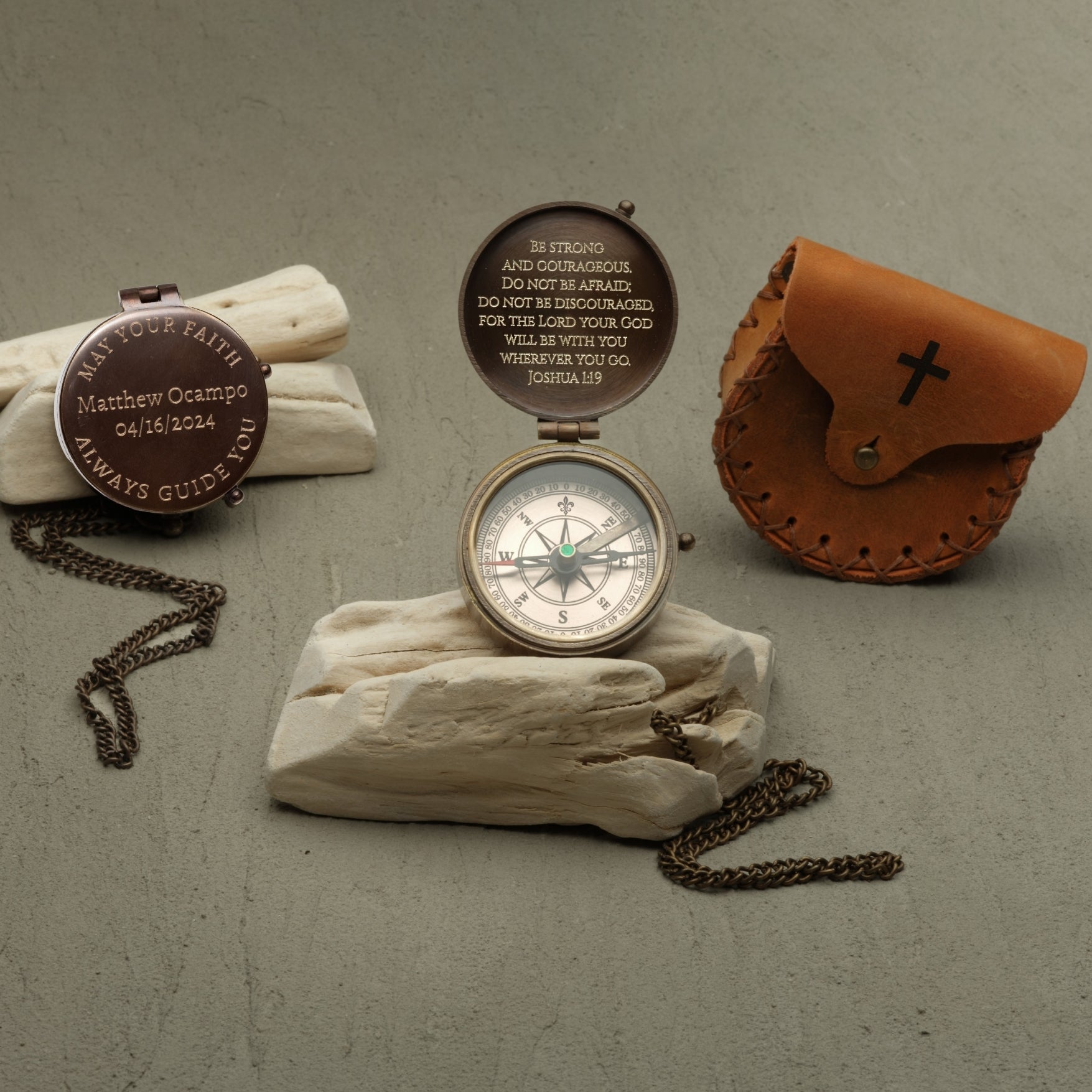 Compass with engraved text on a stone surface, surrounded by decorative items.