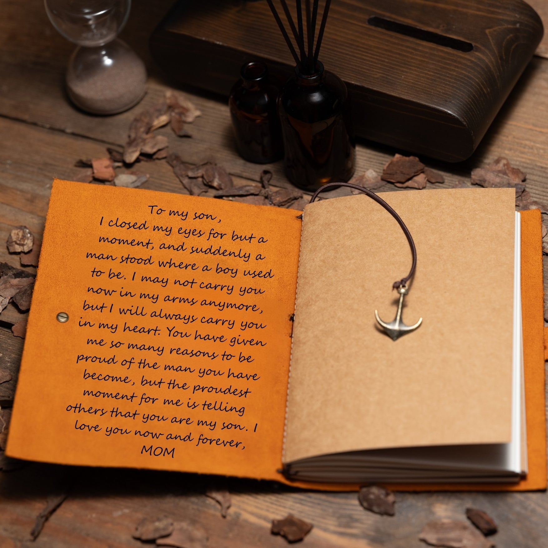 Open book with a letter to a son and an anchor bookmark on a wooden surface.